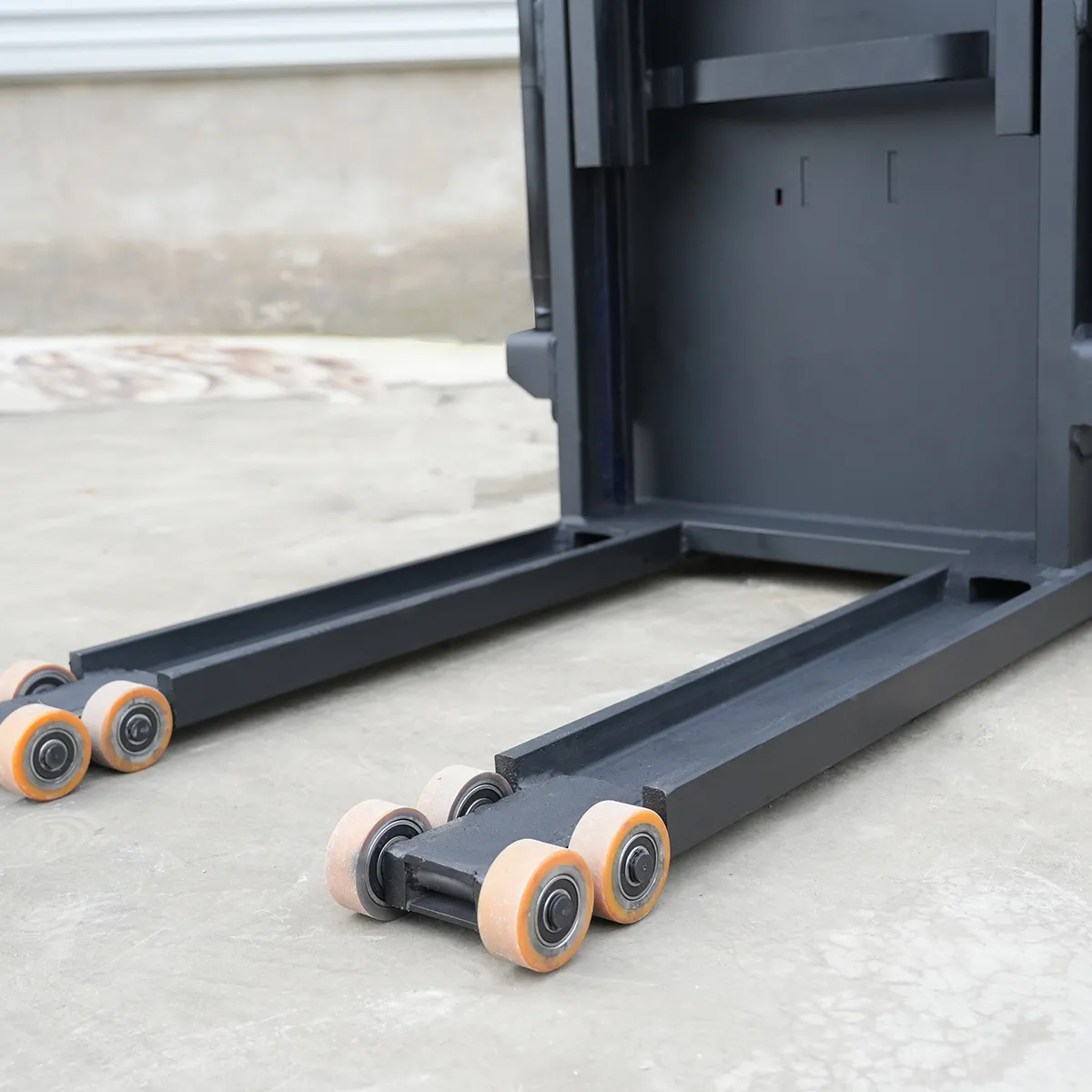 2.5-ton Stand-Drive All-Electric Forklift – Detail View – Forks and Load Wheels 3