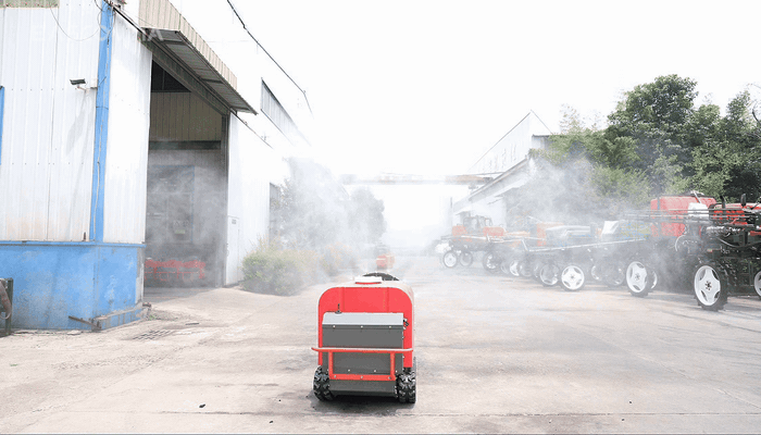 Fan airflow works with nozzles around the housing, carrying mist toward both sides and upward from the spraying assembly.