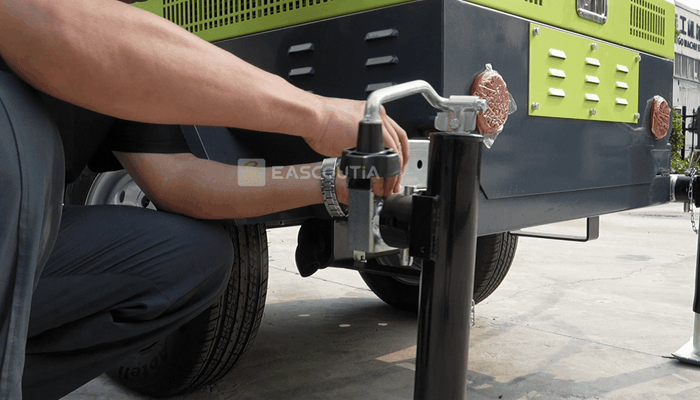 The side stabilizer deploys and adjusts through its hand crank, adding a ground contact point to prepare the trailer before the mast is raised