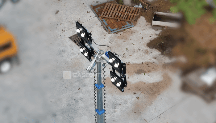 The upper lighting assembly adjusts its tilt, moving the lamp units together to redirect the beam according to the work target and site position