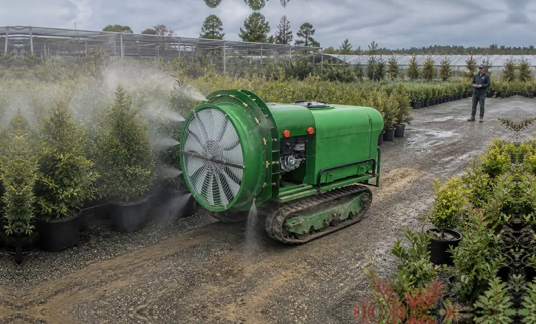 Fine mist protects nursery plants along organized growing beds.