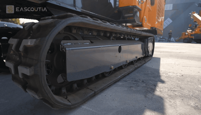 The tracked undercarriage moves the machine smoothly forward on a hard surface.