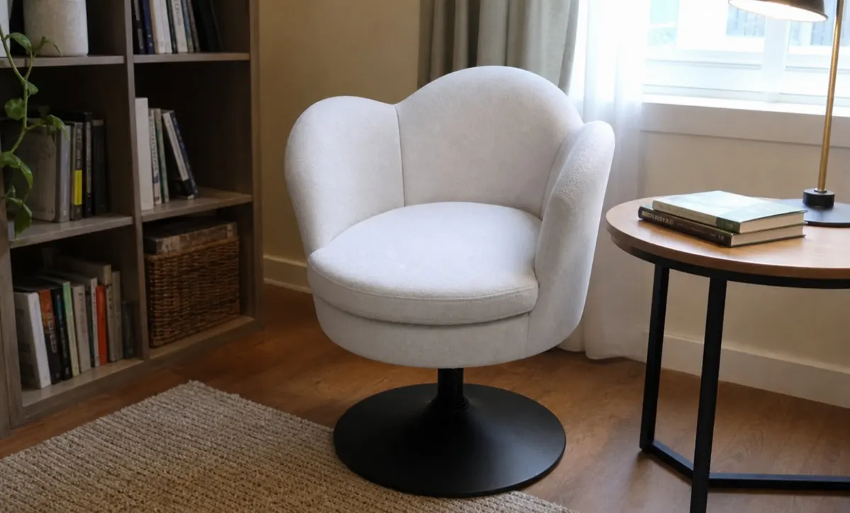 Compact chair beside books and a table in a quiet reading corner.