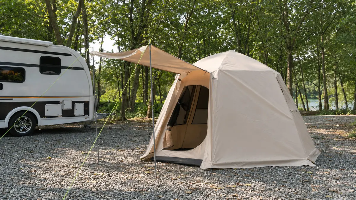 Road-trip tent beside an RV, providing mobile shelter for rest and outdoor gear.